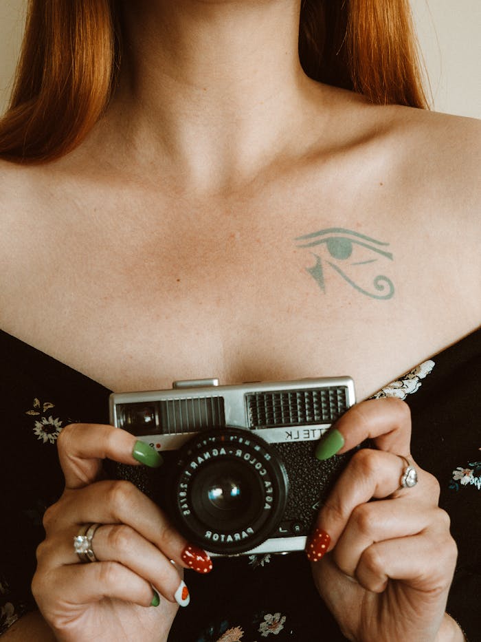 A Woman Holding a Vintage Camera 